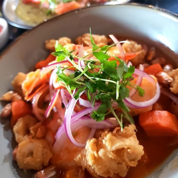 Chronic Sushi's fried calamari and shrimp in red sauce, topped with red onions and cilantro.